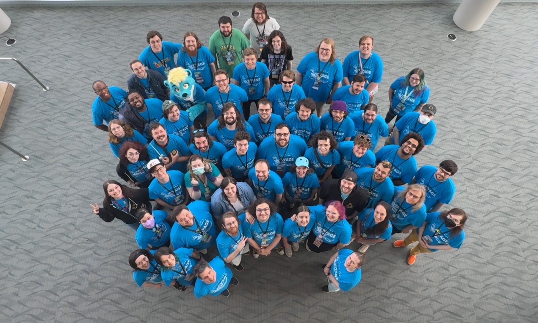 Team of 80+ posing together for a photo at a recent event